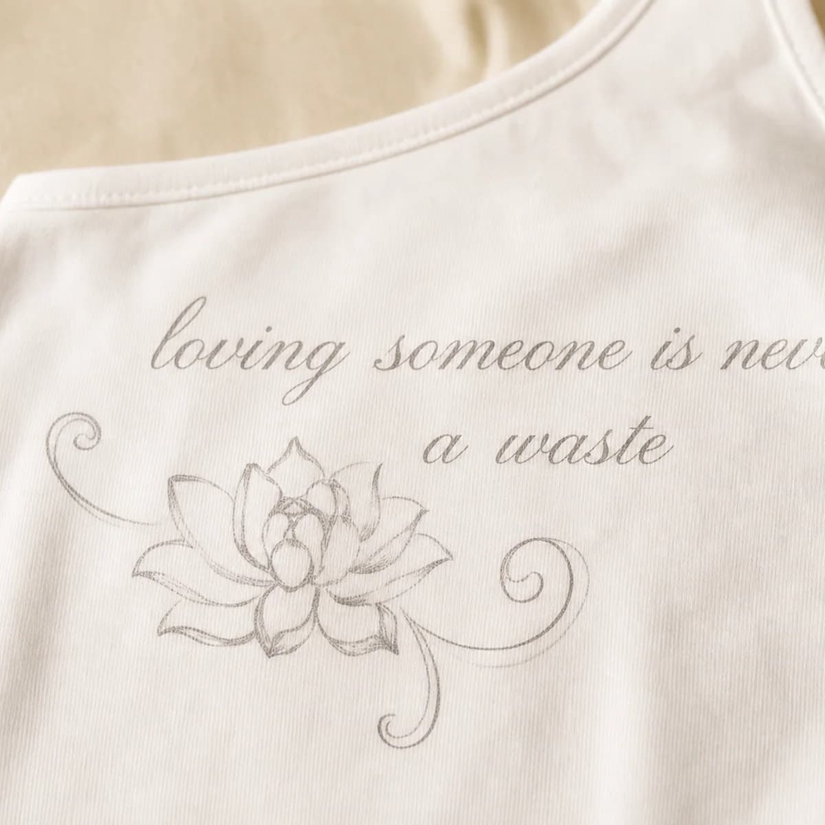 Close-up of the gray cursive lotus artwork on The Signature Graphic Top